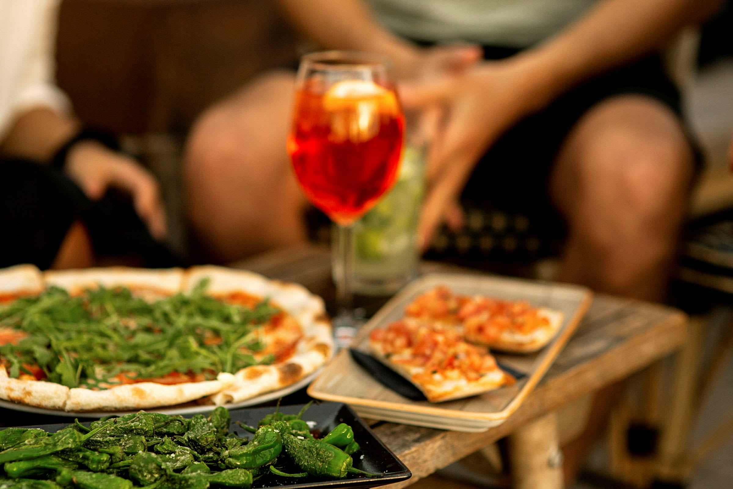 Näkymä pizzasta, grillatuista paprikoista ja bruschetasta tarjoiltuna juoman kanssa. (Tekoälyn luoma teksti)