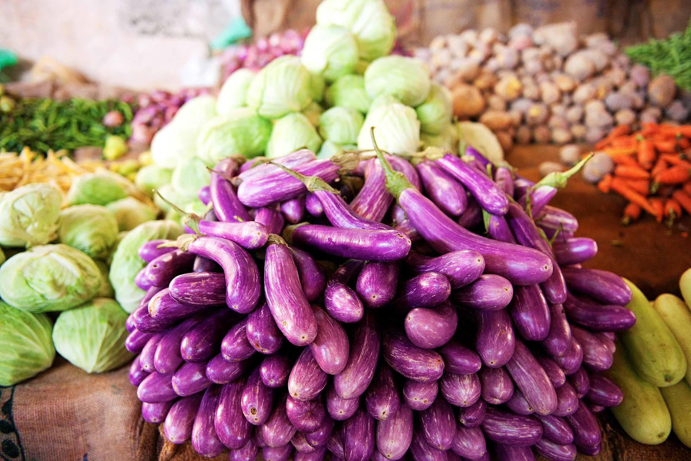 Violette munakoisot pinottuina markkinoilla, muiden vihannesten ympäröiminä. (Tekoälyn luoma teksti)