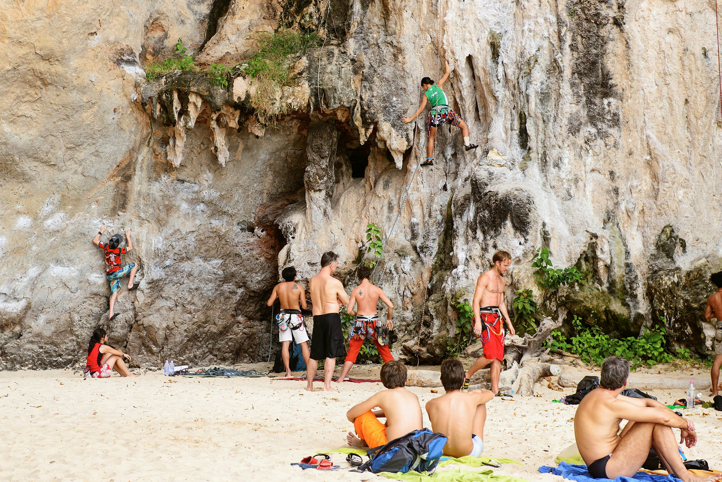 Henkilöitä kiipeilemässä kallioilla rannalla. (Tekoälyn luoma teksti)