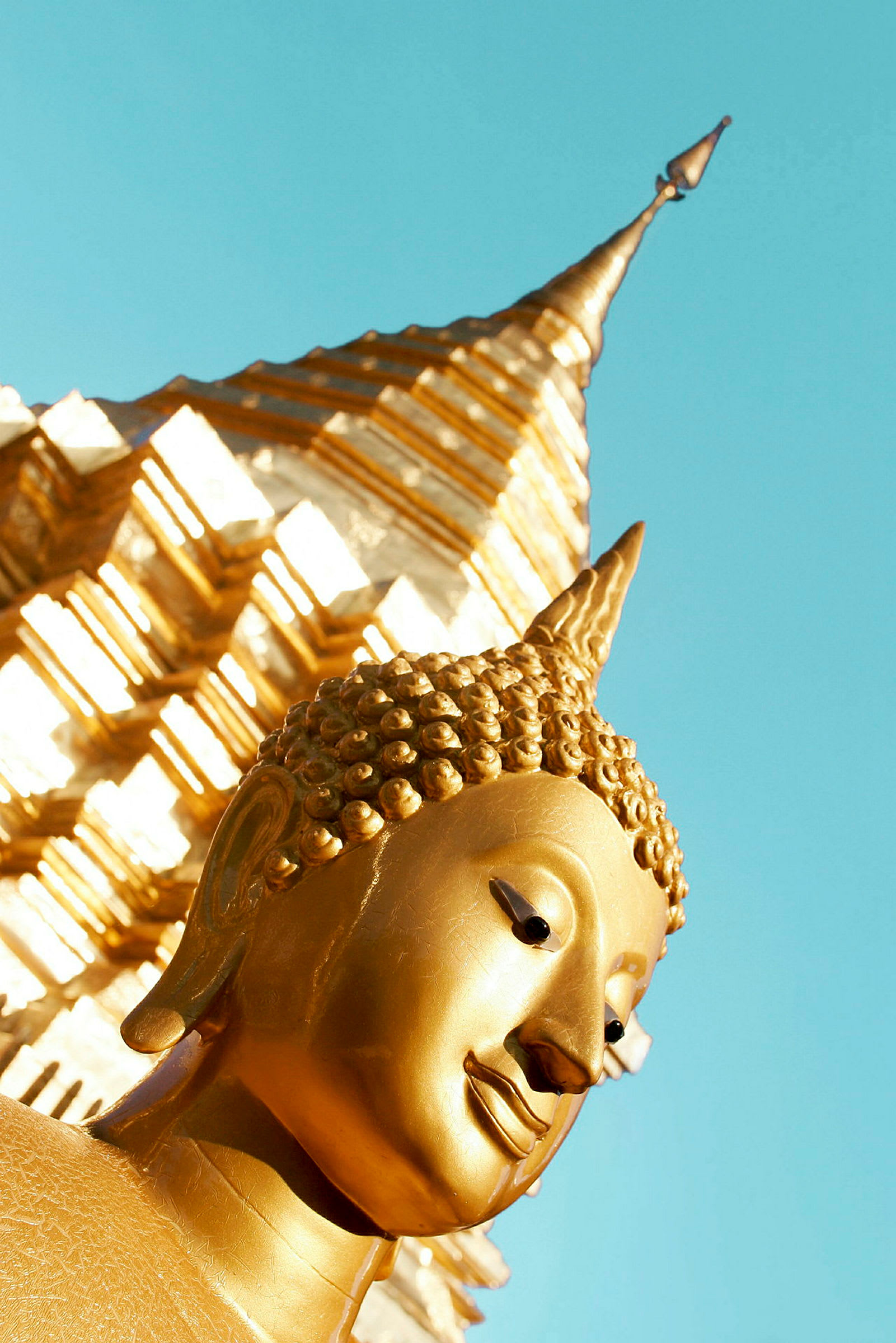 Kultaiset yksityiskohdat buddhalaiseen patsaan kanssa, jossa taustalla stupan. (Tekoälyn luoma teksti)
