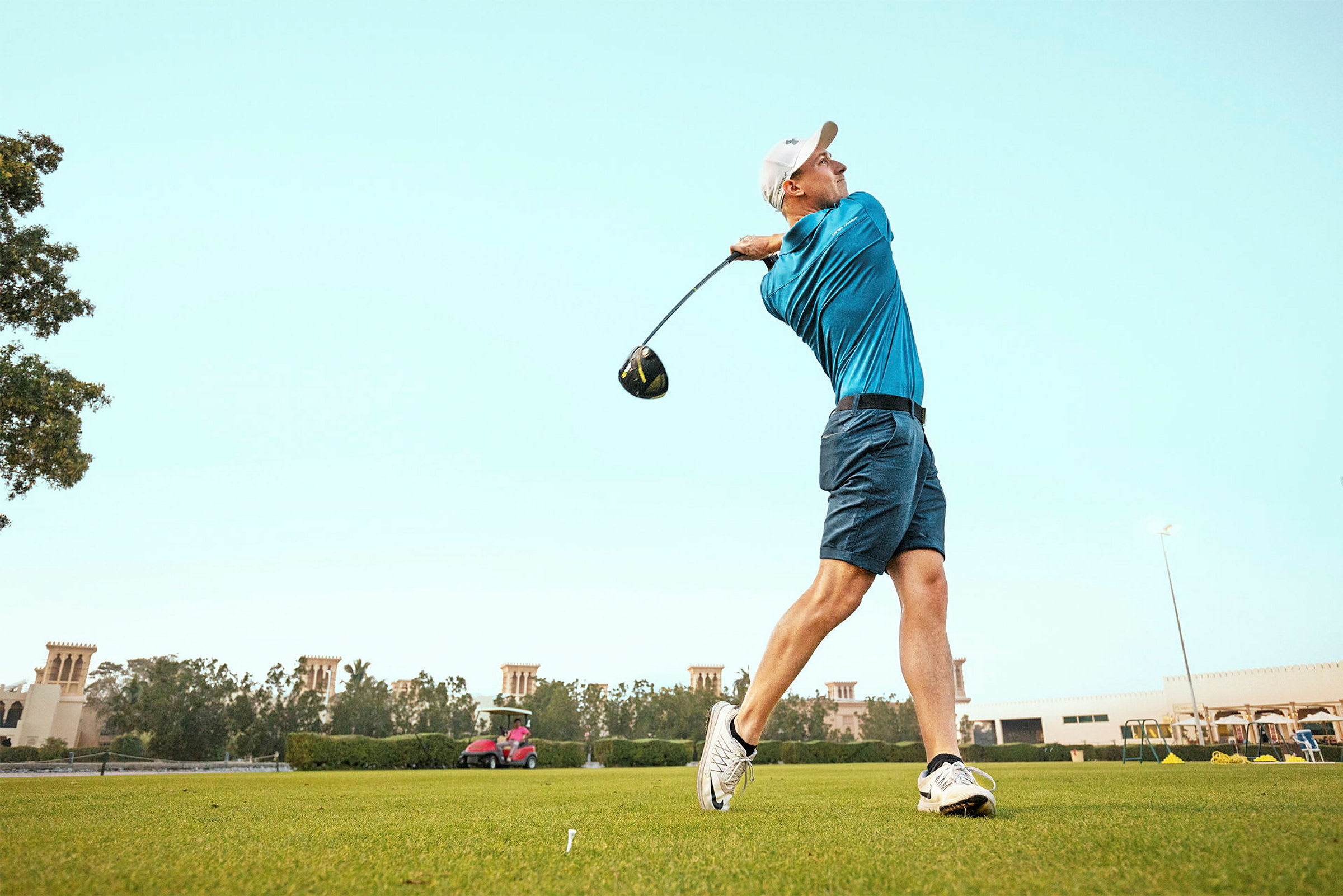Henkilö pelaa golfia ja heilauttaa mailaa vihreällä golfkentällä. (Tekoälyn luoma teksti)