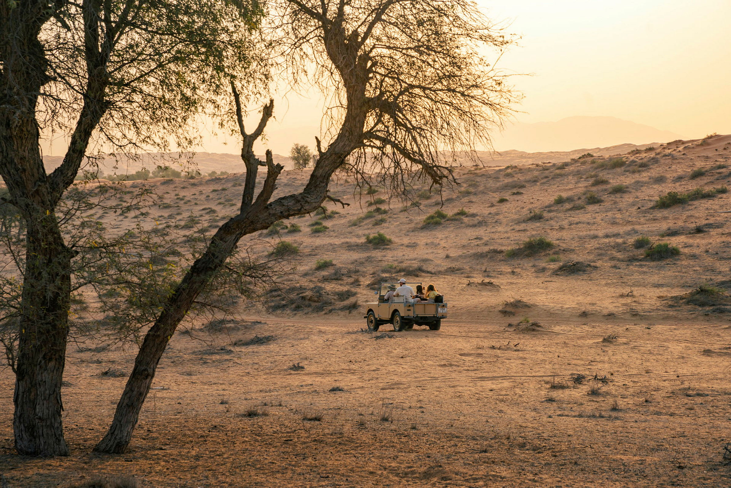 Jeep kulkee autiomaamaiseman läpi auringonlaskun aikaan. (Tekoälyn luoma teksti)