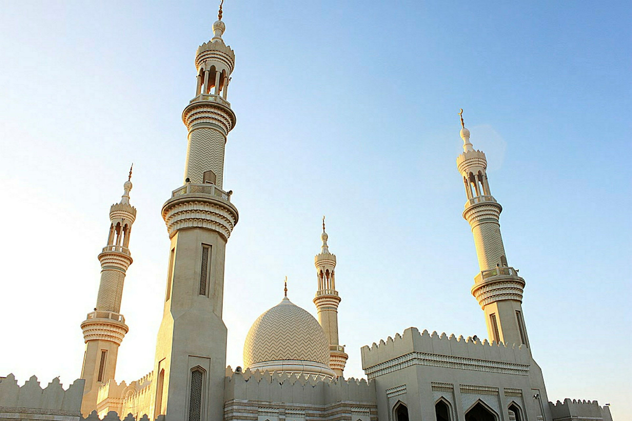 Moskeija, jossa on useita minareetteja kirkasta taivasta vasten. (Tekoälyn luoma teksti)