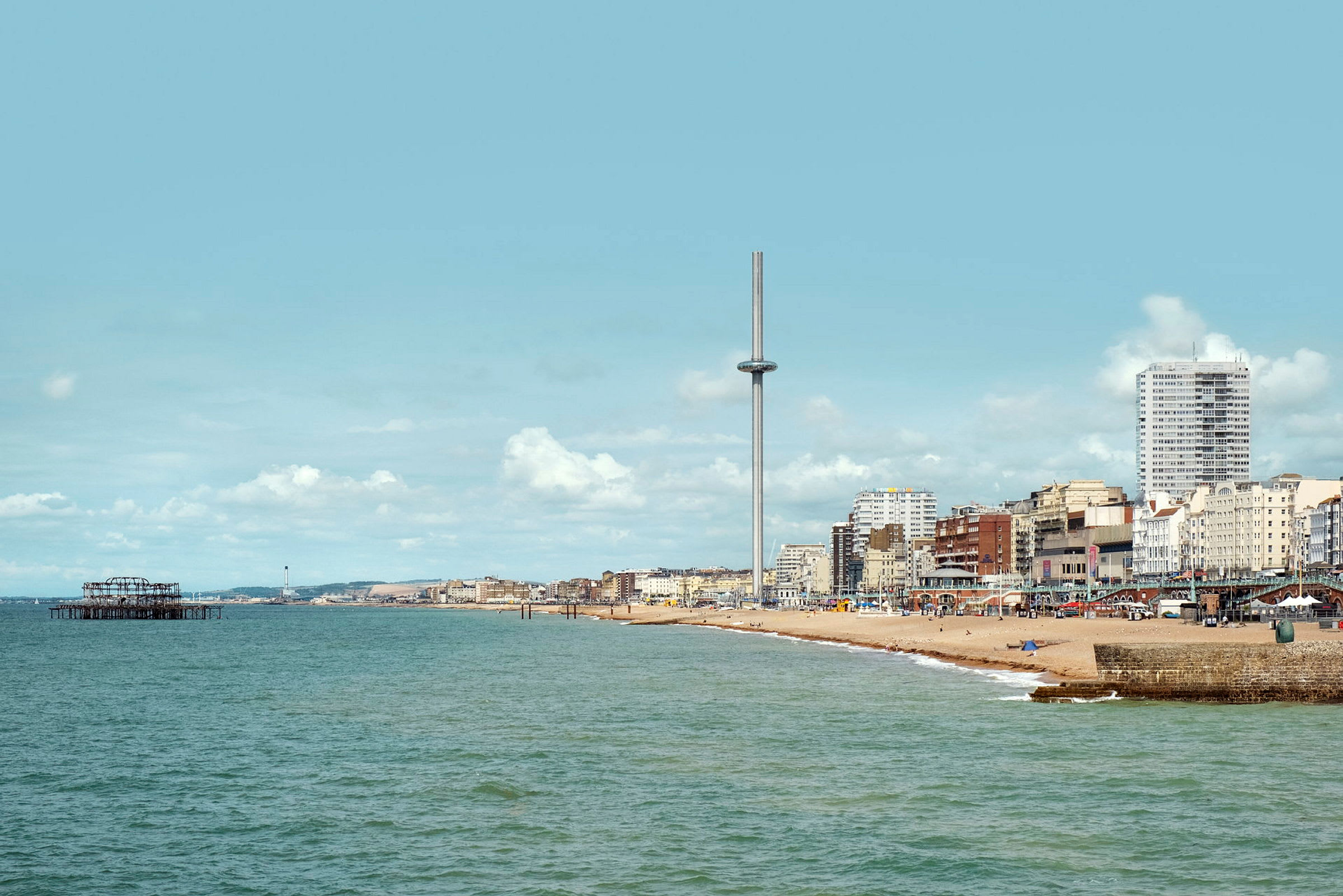Näköala Brightonin mereen ja rannalle, taustalla i360-torni ja rakennuksia. (Tekoälyn luoma teksti)