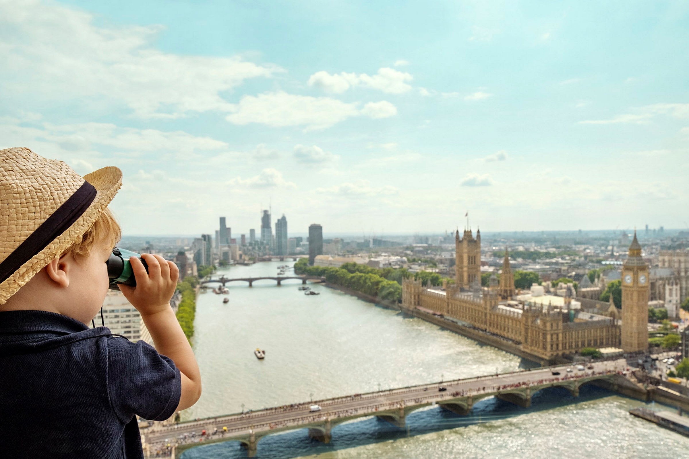 Lapsi hatussa katselee kiikarin läpi Lontoossa, jossa näkyy parlamenttitalo ja Thames-joki. (Tekoälyn luoma teksti)