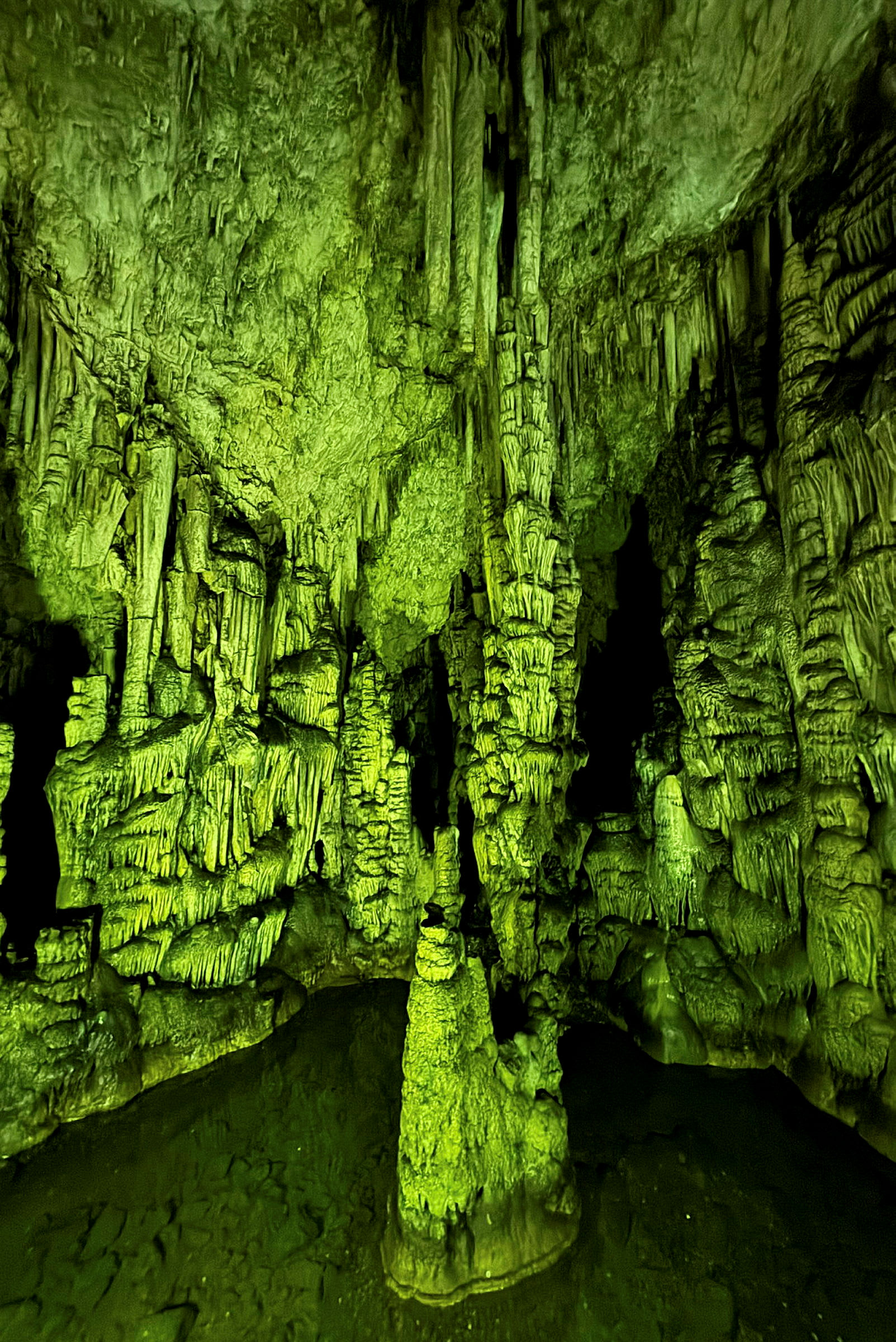 Valaistu luola, jossa on tippukiviä ja stalagmiittejä. (Tekoälyn luoma teksti)