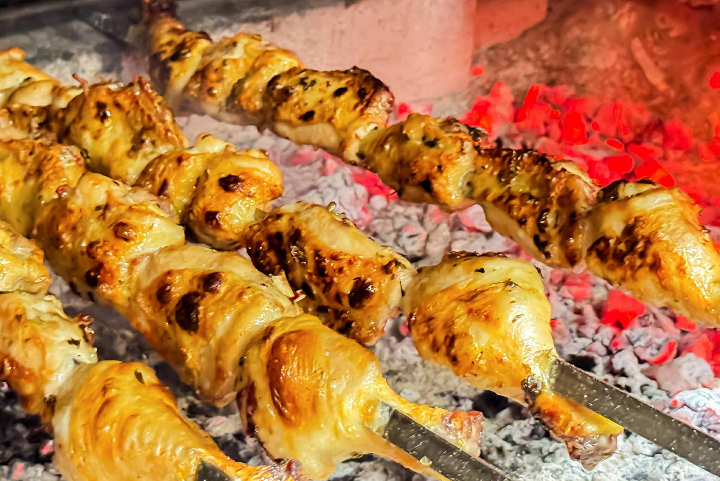 Grillattua kanaa vartaassa hehkuvan hiilen yllä. (Tekoälyn luoma teksti)