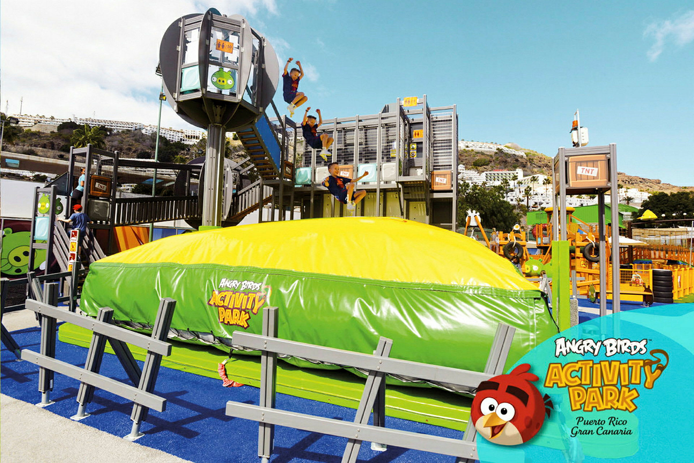 Angry Birds Activity Parkin ulkoalue, jossa on suuri puhallettava tyyny ja useita leikkirakenteita. (Tekoälyn luoma teksti)