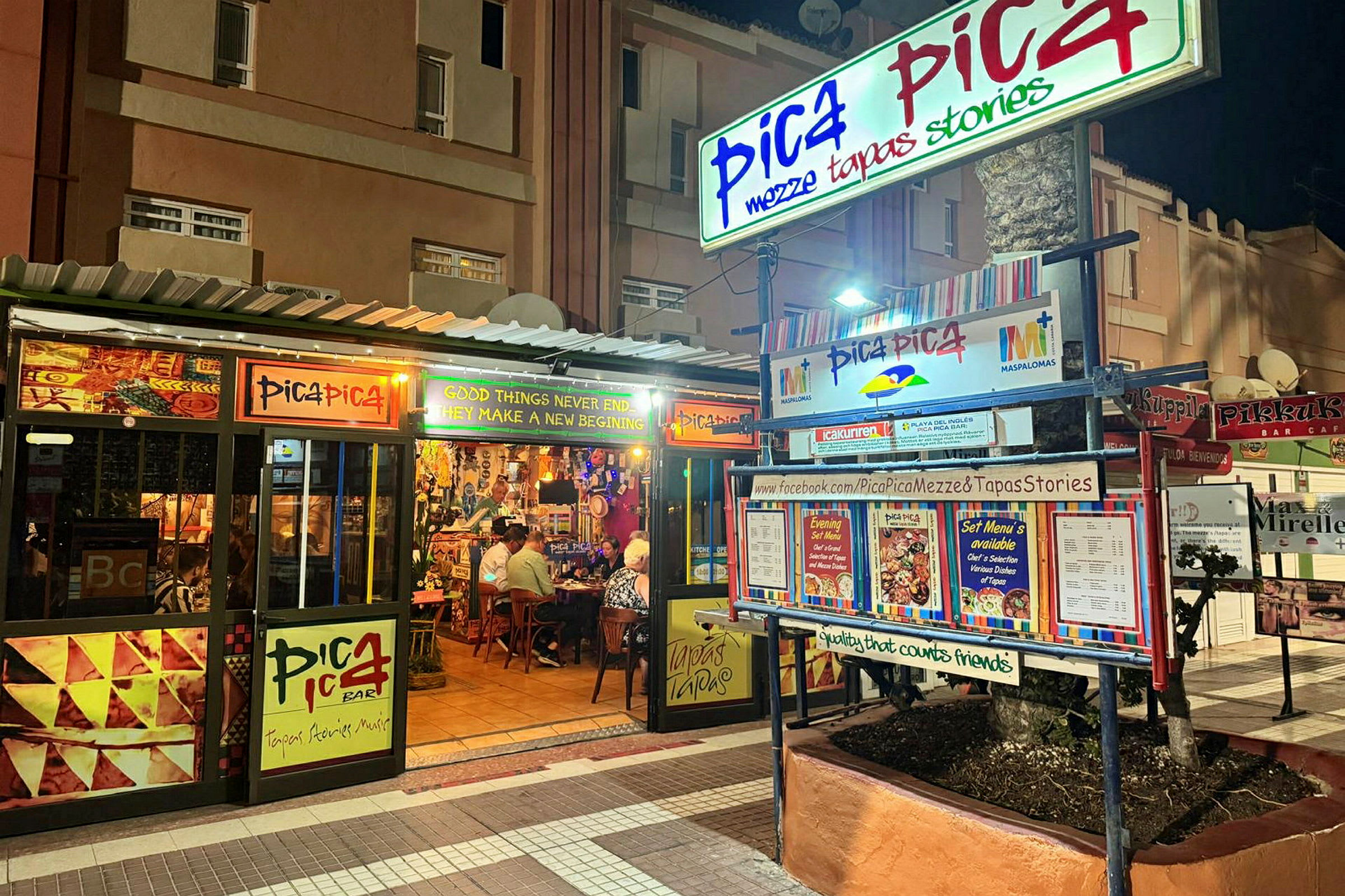 Ravintola Pica Pica näkyy yöllä. Ulkopuolella on kylttejä ja ruokalistoja. (Tekoälyn luoma teksti)