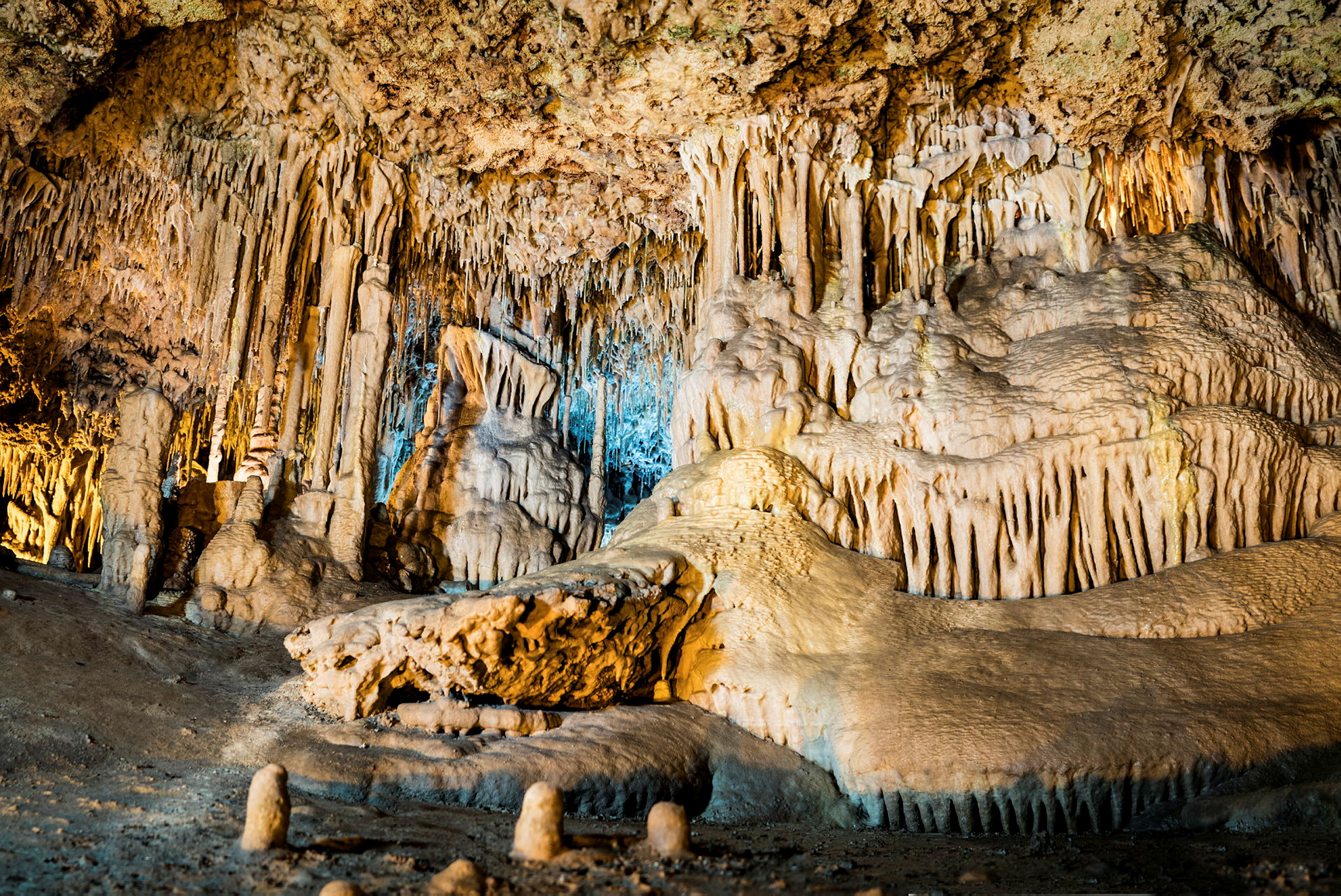 Kuva kalkkikiviluolasta, jossa on tippukiviä ja stalagmiitteja. (Tekoälyn luoma teksti)
